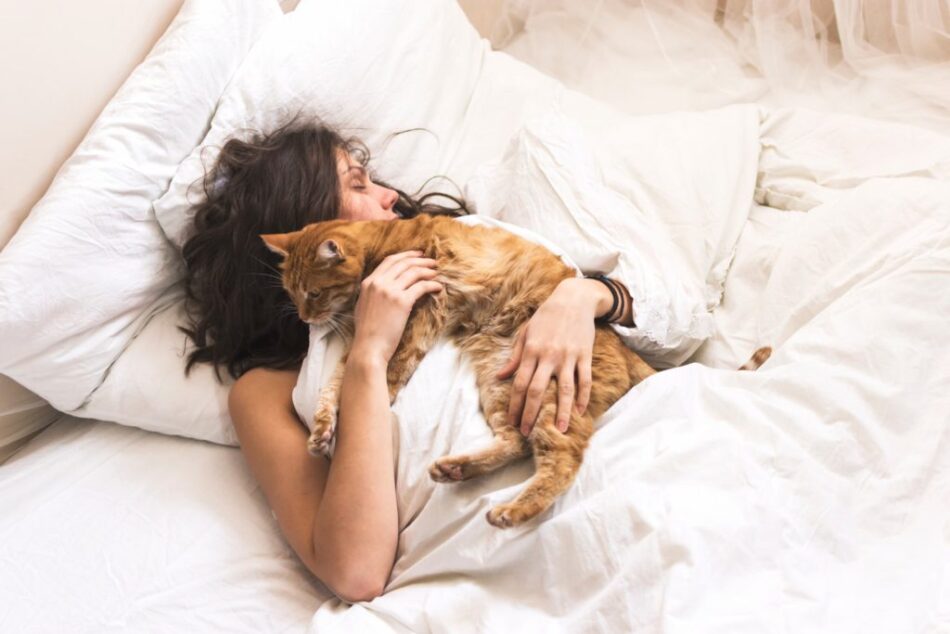 Femme endormie dans son lit, câlinant son chat