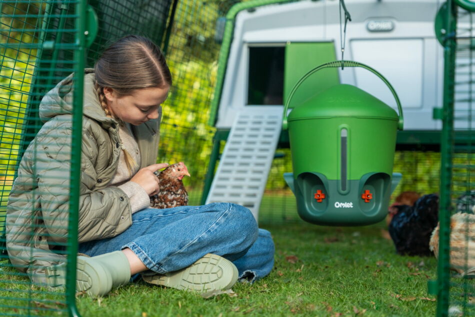fille qui tient une poule devant un poulailler eglu pro
