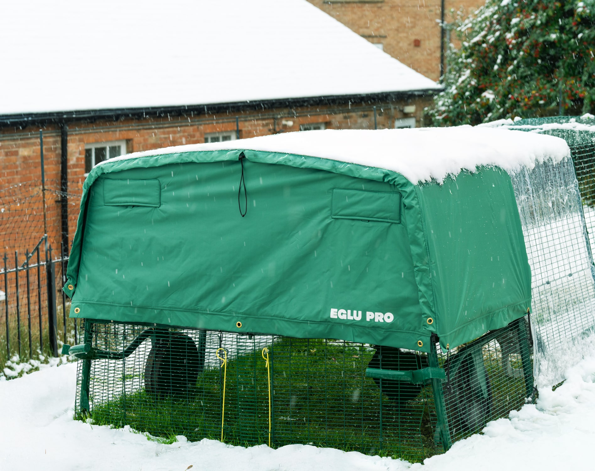 poulailler Eglu Pro dans la neige dans un jardin avec une bâche de protection