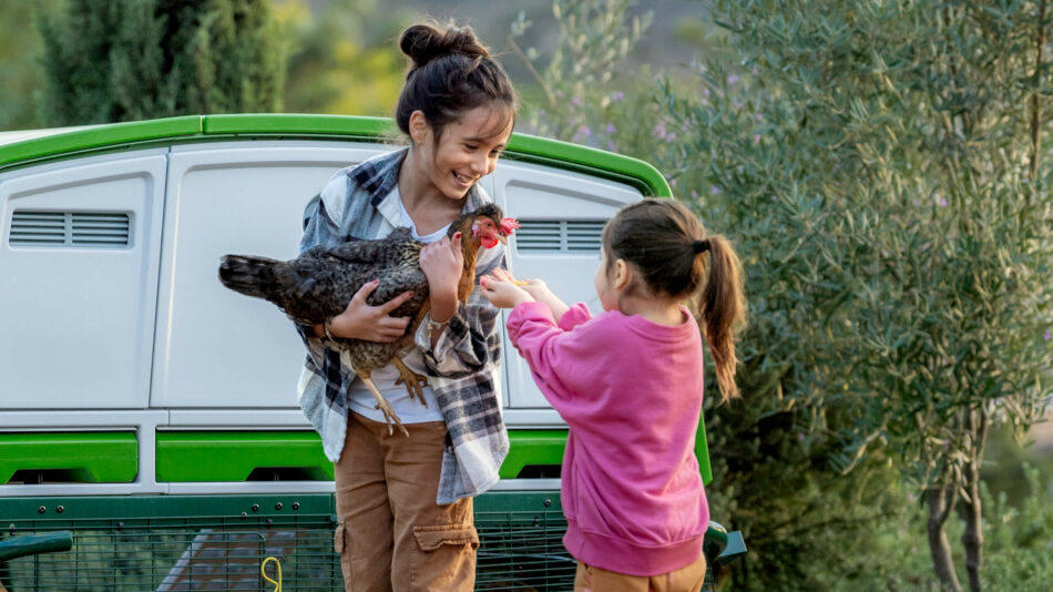 Deux filles avec une poule près du poulailler Eglu Pro