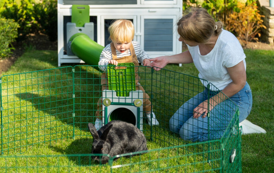 Femme et enfant qui jouent avec un lapin dans le parc de jeu Zippi
