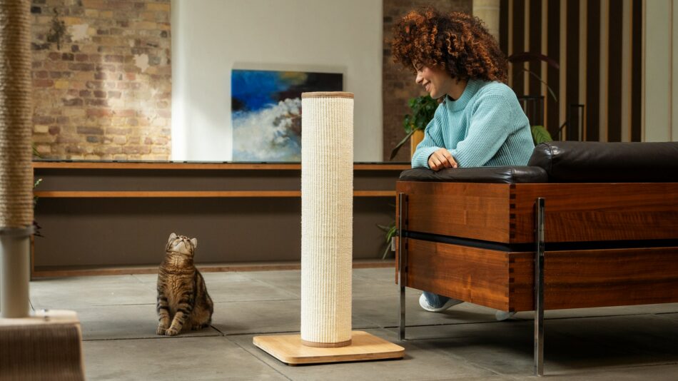 Femme et son chat qui se regardent avec un griffoir pour chat Switch
